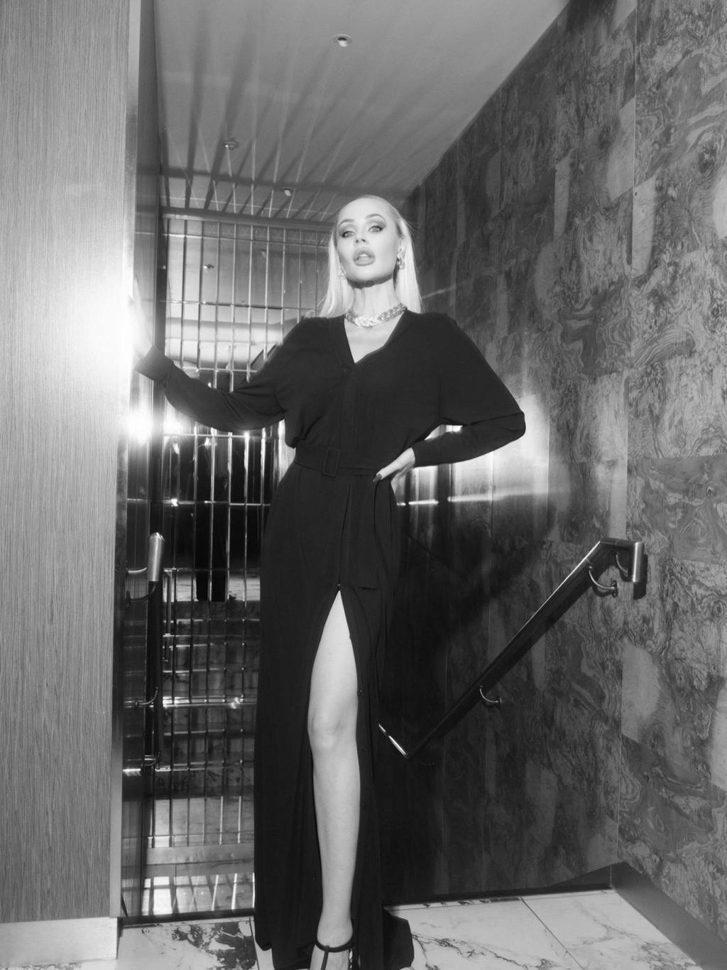 In black, in a marble hall, dressed for the theatre